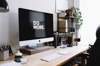 Home office desk with computer screen showing Do More