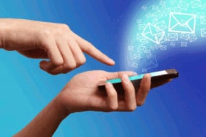 Pair of hands holding mobile phone with envelope icons floating out of phone