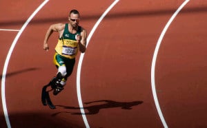 Athlete with two prosthetic legs running on race track