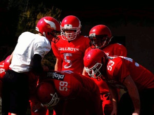 Football team huddling up around quarterback