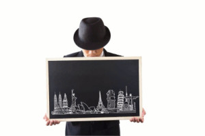 Man in suit and hat holding chalkboard