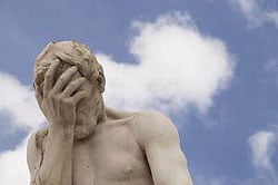 Statue of man holding his head in regret